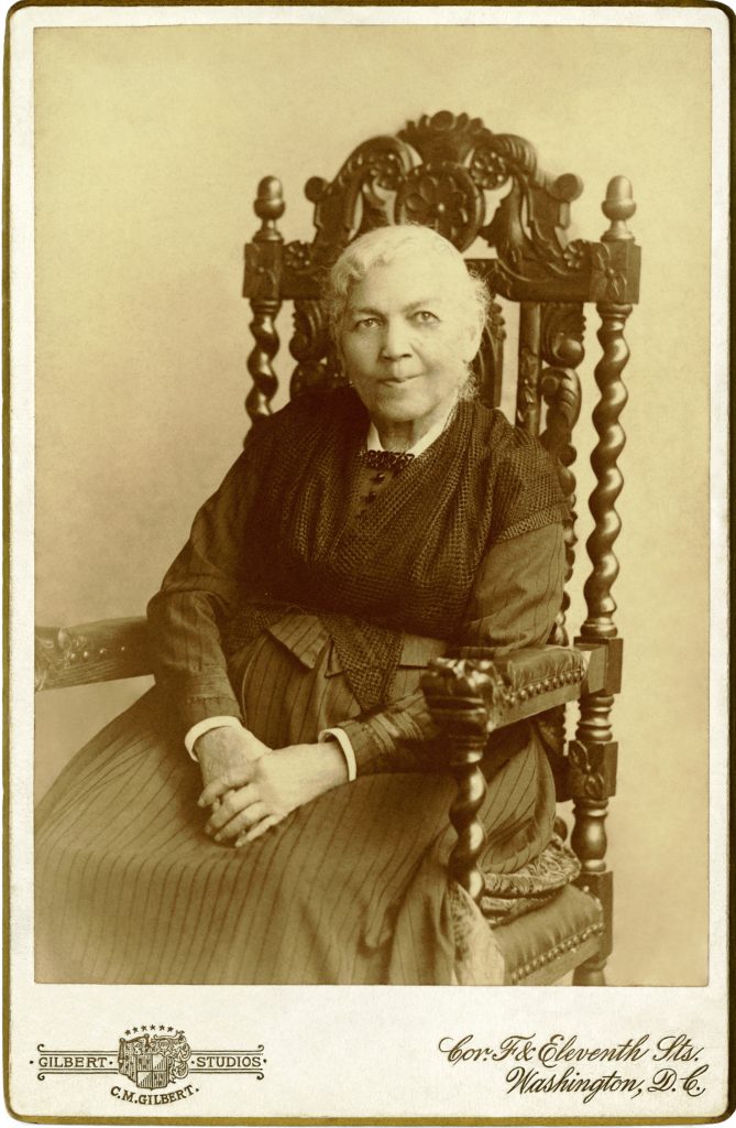 Formal three-quarter length photographic portrait of an elderly Harriet Jacobs in a dark-colored dress and shawl