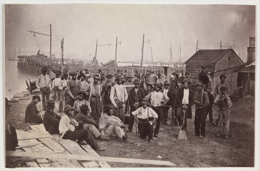 Group of Black laborers, some holding their tools, on a wharf in Alexandria
