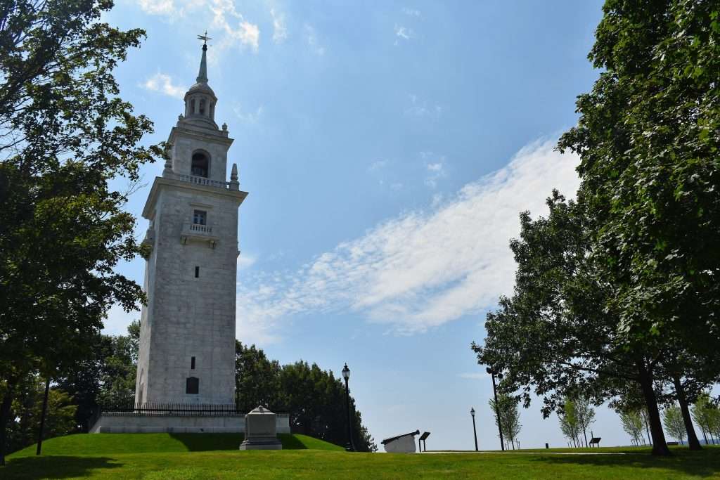 Dorchester Heights Monument, a white granite stepped tower surrounded by trees and grass