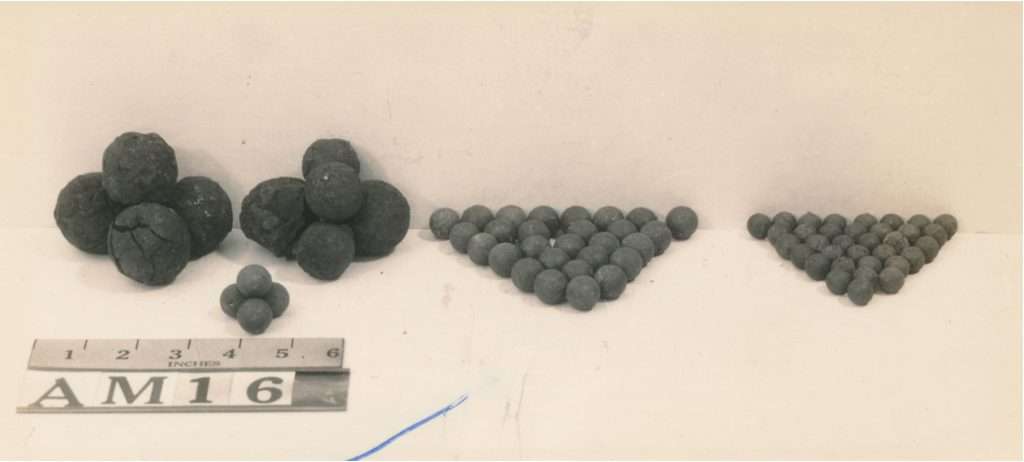 black and white picture of lead shot of different sizes, organized in piles of largest to smallest